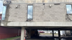 A multi-story parking garage with concrete walls and a tiled roof.