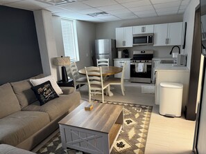 A modern living room with a sofa, coffee table, and dining area.