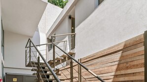Una escalera con barandillas metálicas y escalones de madera que conducen a un piso superior.