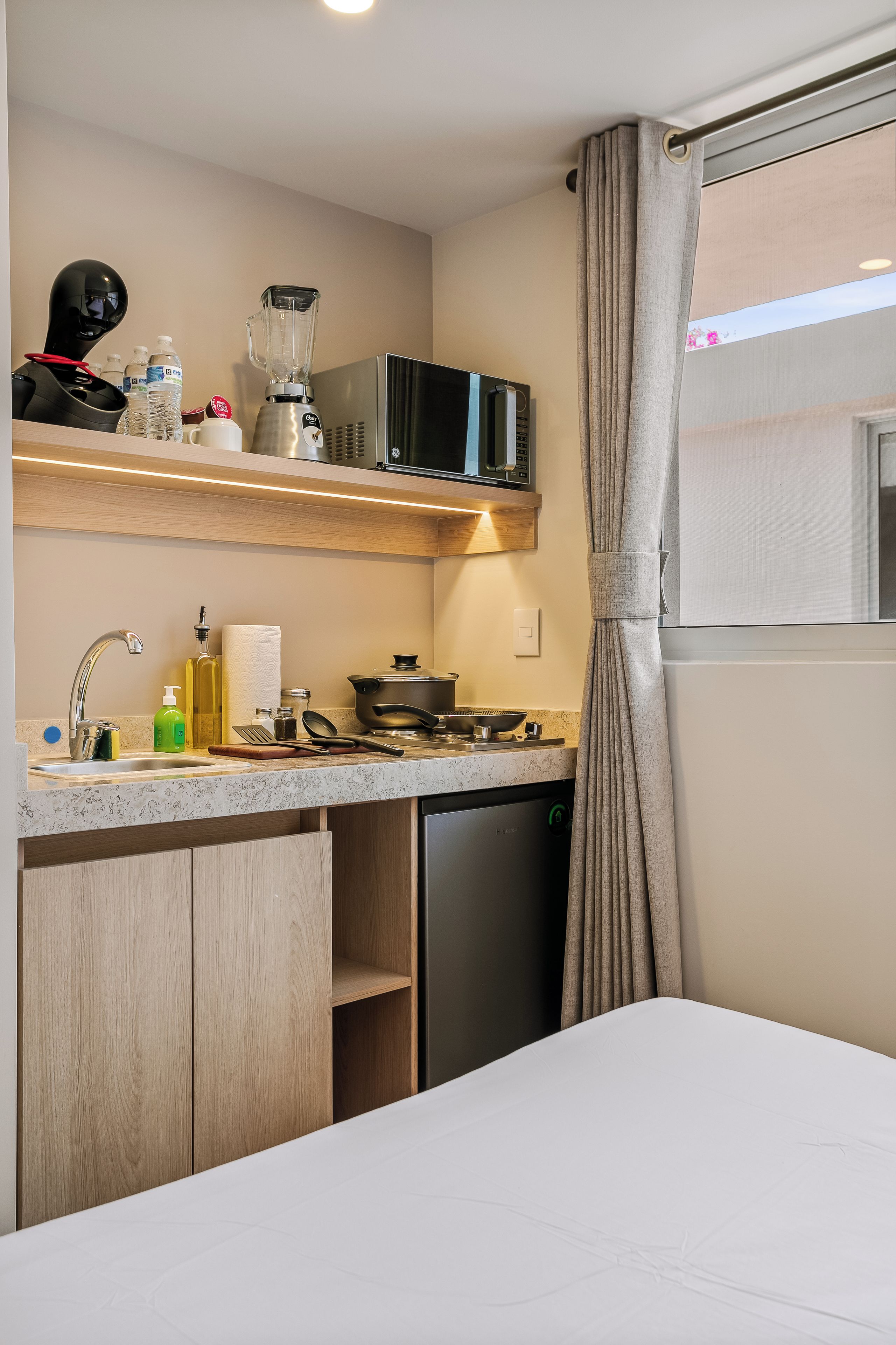 A compact kitchenette with a microwave, toaster, and a small refrigerator.