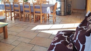 Un comedor con chimenea de piedra, muebles de madera y un lámpara colgante.
