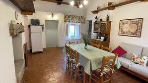 Une cuisine rustique avec une table à manger, des chaises en bois, un réfrigérateur et un plafond en bois.