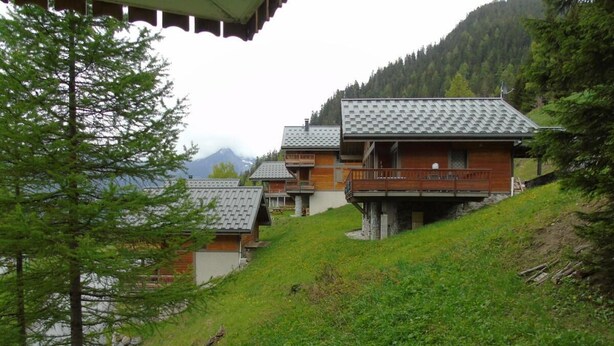A hillside property with multiple chalet-style buildings, each with a sloped roof and wooden exterior. - 4th floor, view mountain, terrace, balcony, tv, ski locker, 36m², Valfréjus (Valfréjus)