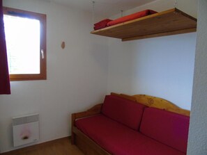 A small room with a wooden sofa, a window, and a radiator. - 4th floor, view mountain, terrace, balcony, tv, ski locker, 36m², Valfréjus (Valfréjus)