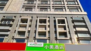 A building with multiple windows and balconies. There is a sign with the text "XIAOONEI" and another sign with Chinese characters. - Xiaomei Hotel (Beijing Universal Studios Tuqiao Subway Station) (Beijing)