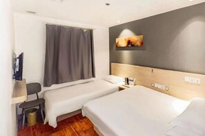 A hotel room with two single beds, a desk, a chair, a small trash bin, and a wall-mounted TV. - Xiaomei Hotel (Beijing Universal Studios Tuqiao Subway Station) (Beijing)