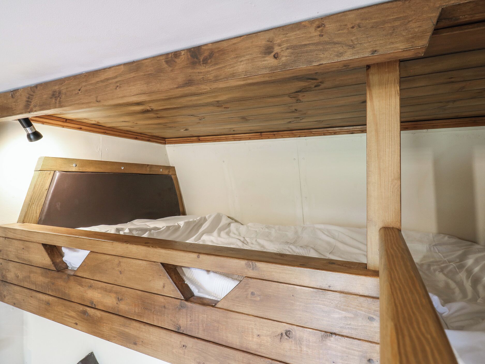 A bunk bed with a wooden frame and a headboard.
