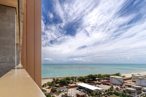 A coastal view from a high vantage point, featuring a beach, ocean, and industrial structures. - Nwts - Studios With Side sea View in Maceio II (Maceió)