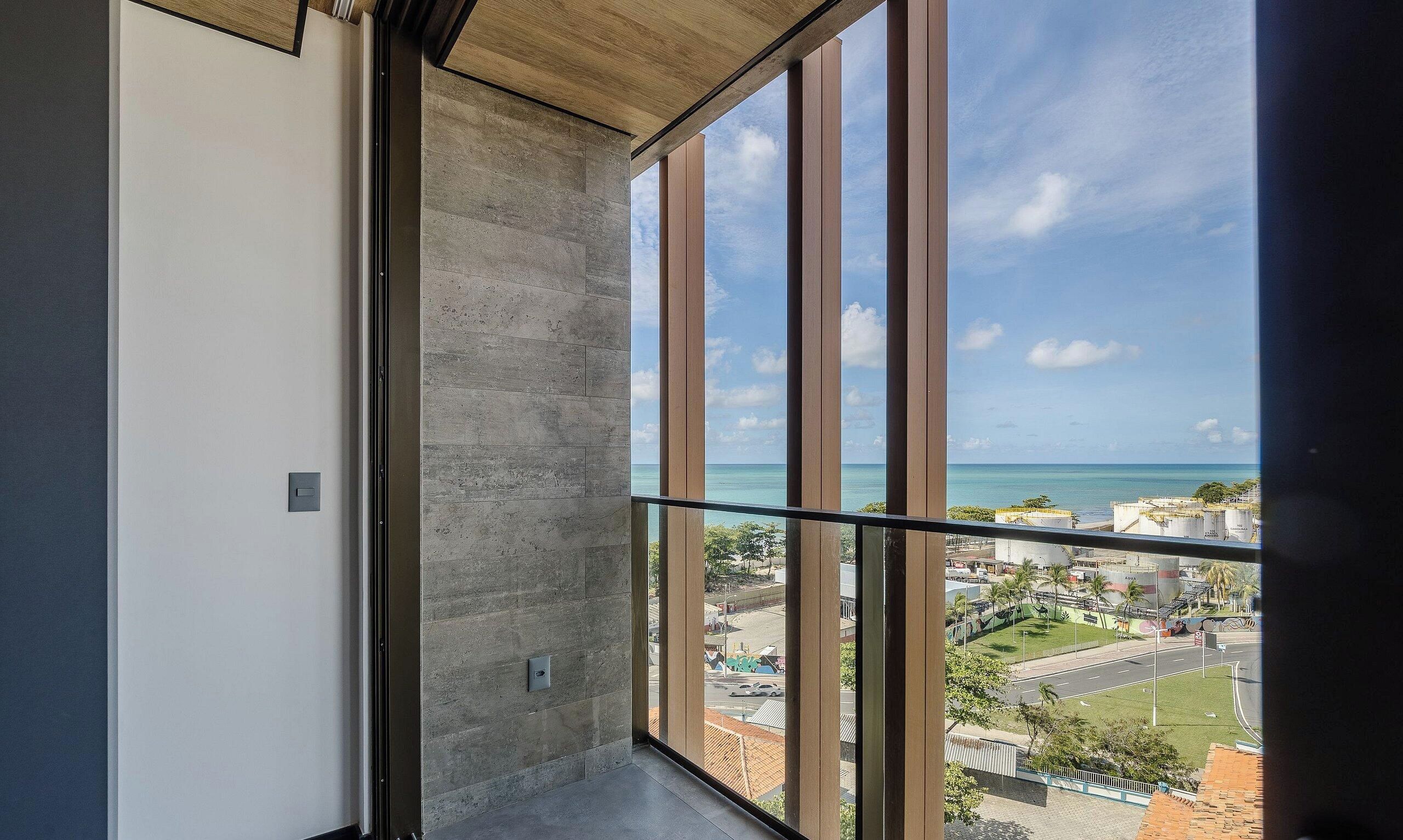 A balcony with a view of a coastal cityscape.