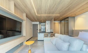 Un ambiente moderno con un divano, un'area pranzo e una cucina.