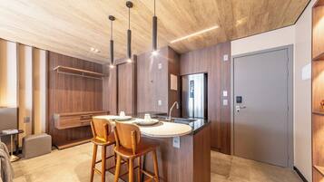 Una cocina moderna con una isla central, muebles de madera e iluminación colgante.