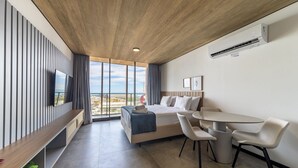 Une chambre d’hôtel moderne, dotée d’un grand lit, d’un bureau et d’un coin repas.