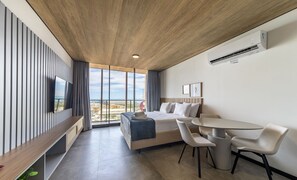 A modern hotel room with a large bed, a desk, and a dining area. - Nwts - Studios With Side sea View in Maceio II (Maceió)