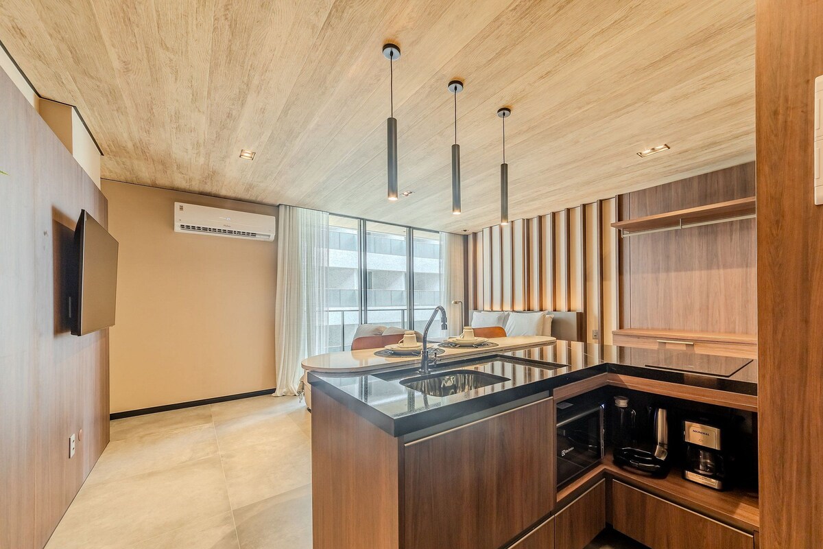 A modern kitchen with a central island, pendant lighting, and built-in appliances.