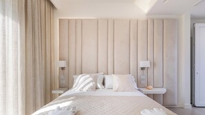 A neatly made bed with a quilted cover, two bedside lamps, and a bedside table with a lamp.