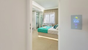 Une chambre d’hôtel moderne équipée d’un lit, d’une table de chevet, d’un miroir et d’un panneau de commande fixé au mur.
