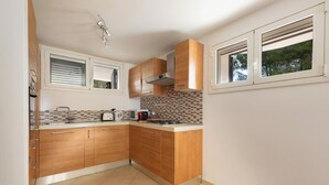 A kitchen with wooden cabinets, a tiled backsplash, and a gas stove. - Villa Madonnina - Trilo Comfort by BarbarHouse (Campomarino)
