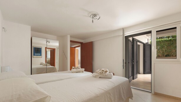 A hotel room with two beds, a large mirror, a ceiling light, and a sliding door leading to an outdoor area. - Villa Madonnina - Trilo Comfort by BarbarHouse (Campomarino)