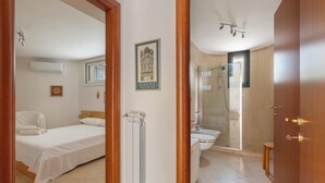 A hotel room with a bed, a radiator, a shower, and a toilet. - Villa Madonnina - Trilo Comfort by BarbarHouse (Campomarino)