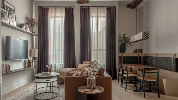 Una sala de estar moderna con sofá, mesa de centro y comedor.