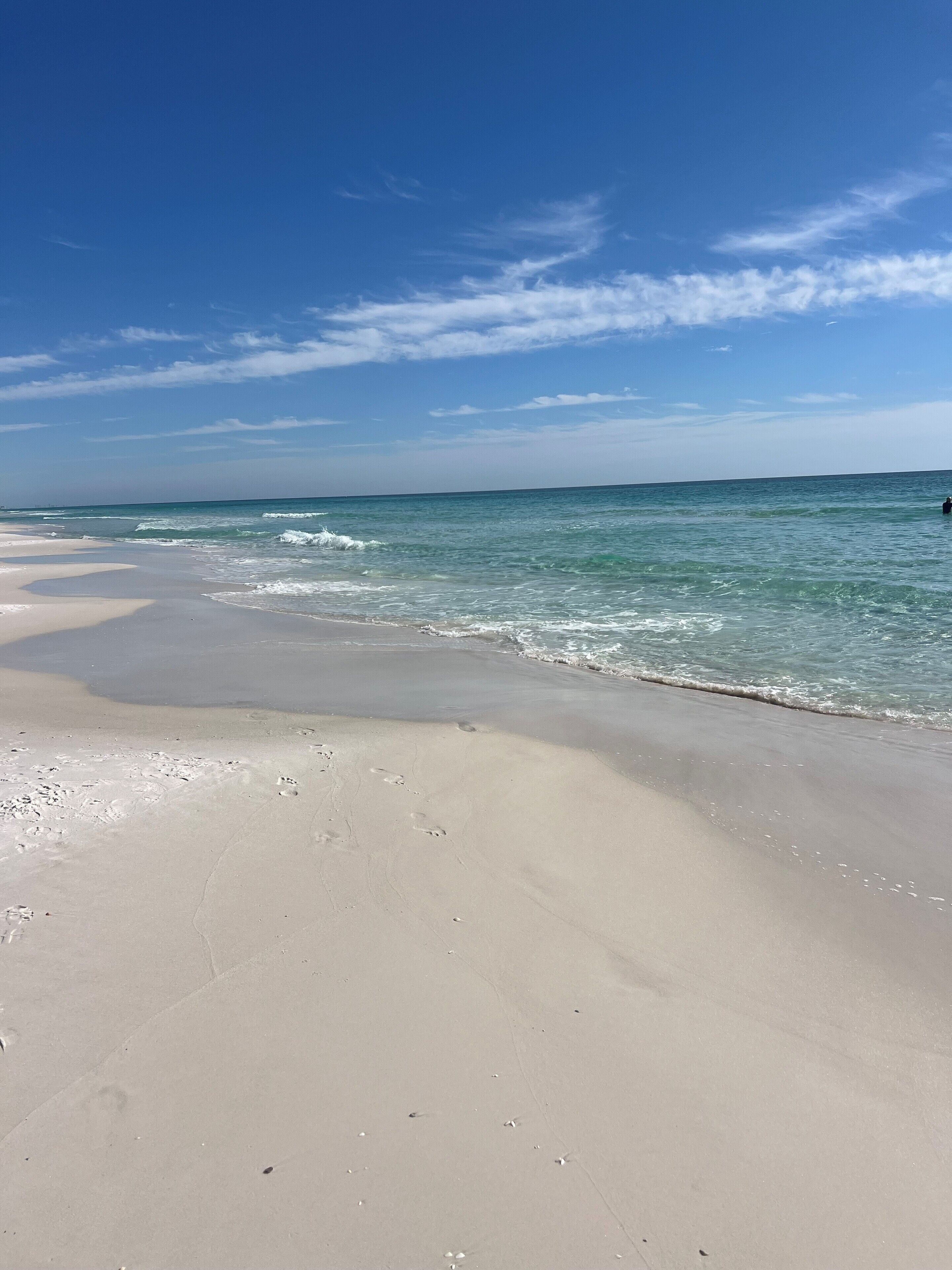 Una playa con agua azul cristalina y una orilla de arena.