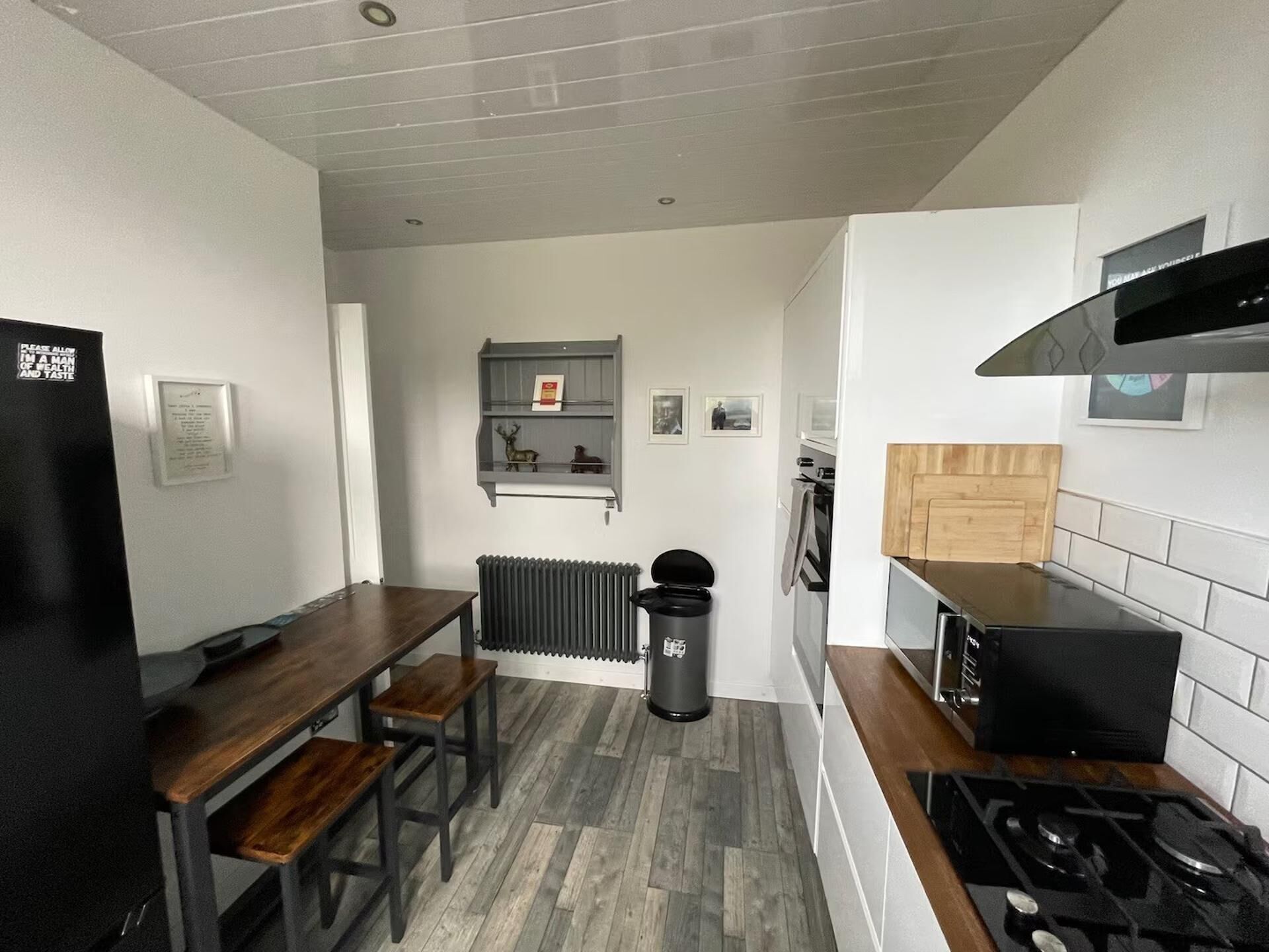 Une cuisine compacte avec une table à manger, un poêle noir et un radiateur.
