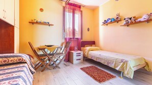 Un dormitorio con cama, escritorio y estanterías llenas de juguetes.