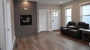 A spacious living room with a fireplace, a sofa, and a desk. - Lauralee’s Legacy House-Minutes to Cedar Point (Sandusky)