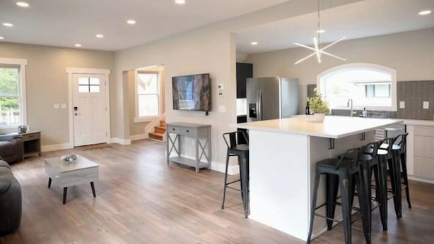 A modern kitchen with a large island, bar stools, and recessed lighting. - Lauralee’s Legacy House-Minutes to Cedar Point (Sandusky)