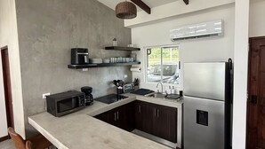 A modern kitchen with a central island, dark wooden cabinets, and stainless steel appliances. - Casa Kai, a house with everything around it: mountains, beaches, tranquility... (Quebrada Ganado)