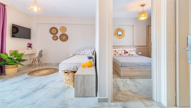 A modern bedroom with a bed, bedside table, and a TV. - Casa Helone  (Kassandra)