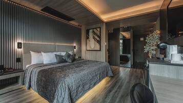 A modern bedroom with a large bed, bedside lamps, a headboard, and a nightstand.