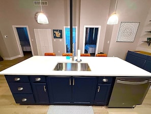 Una cocina con una isla central, un fregadero y armarios.