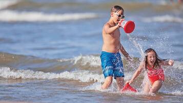 Dos niños jugando en el agua en la playa.