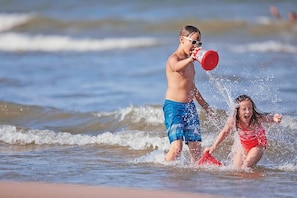 Dos niños jugando en el agua en la playa.