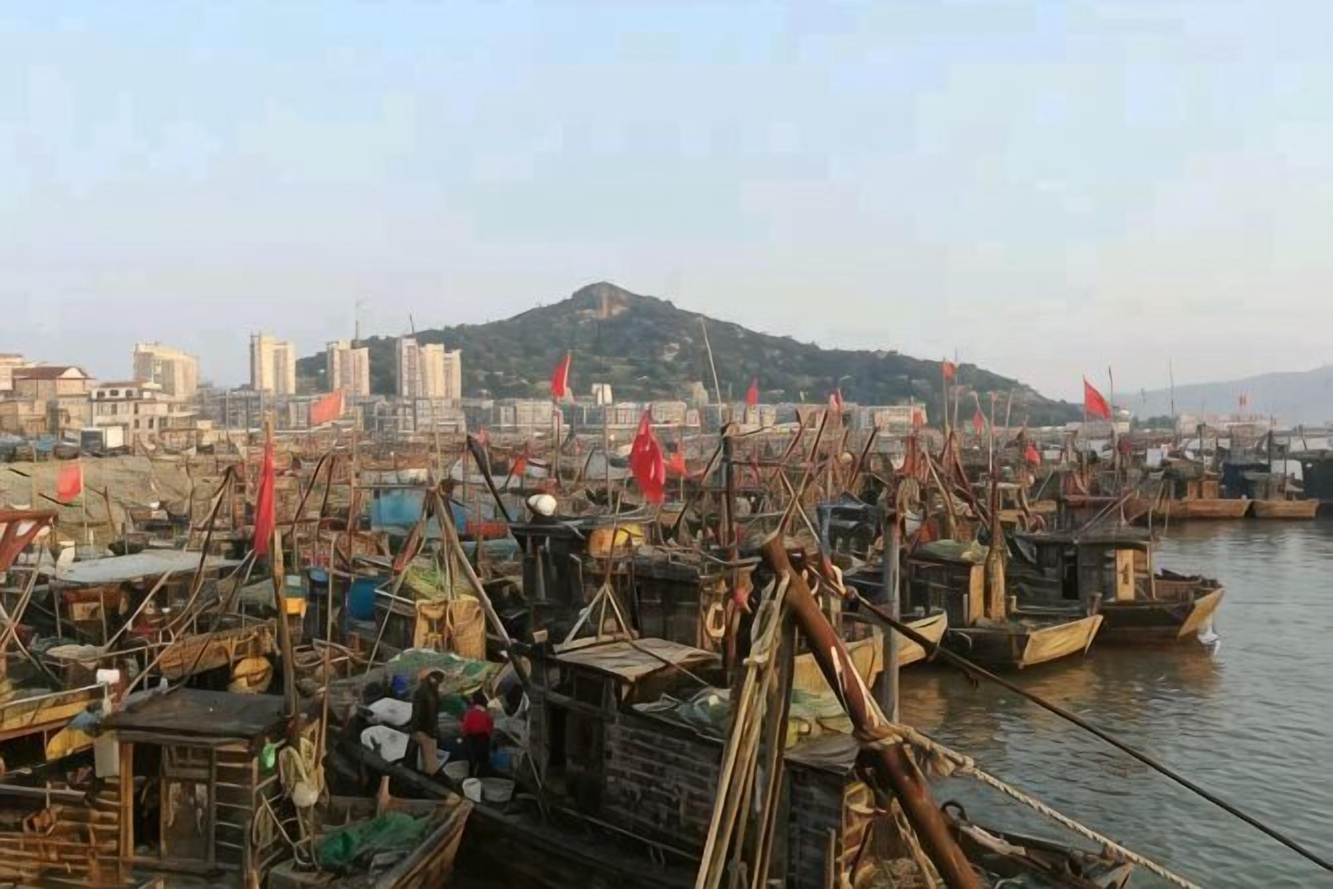A harbor with boats and a cityscape in the background.