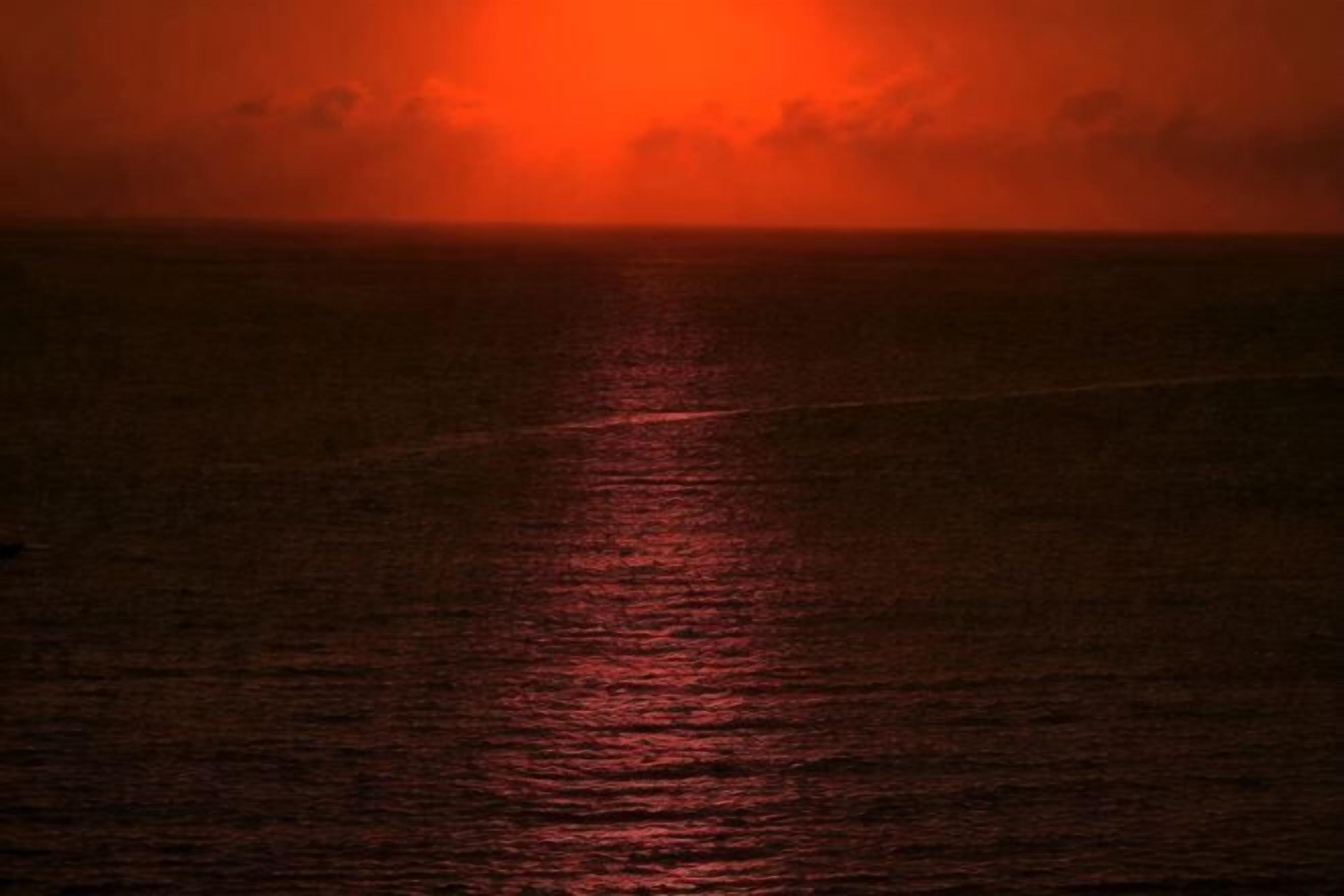 A sunset over the ocean with a visible horizon line.