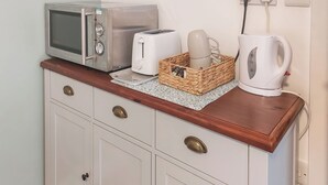 A kitchenette with a microwave, toaster, and kettle on a wooden countertop. - 1 bedroom accommodation in Walcott (Walcott)