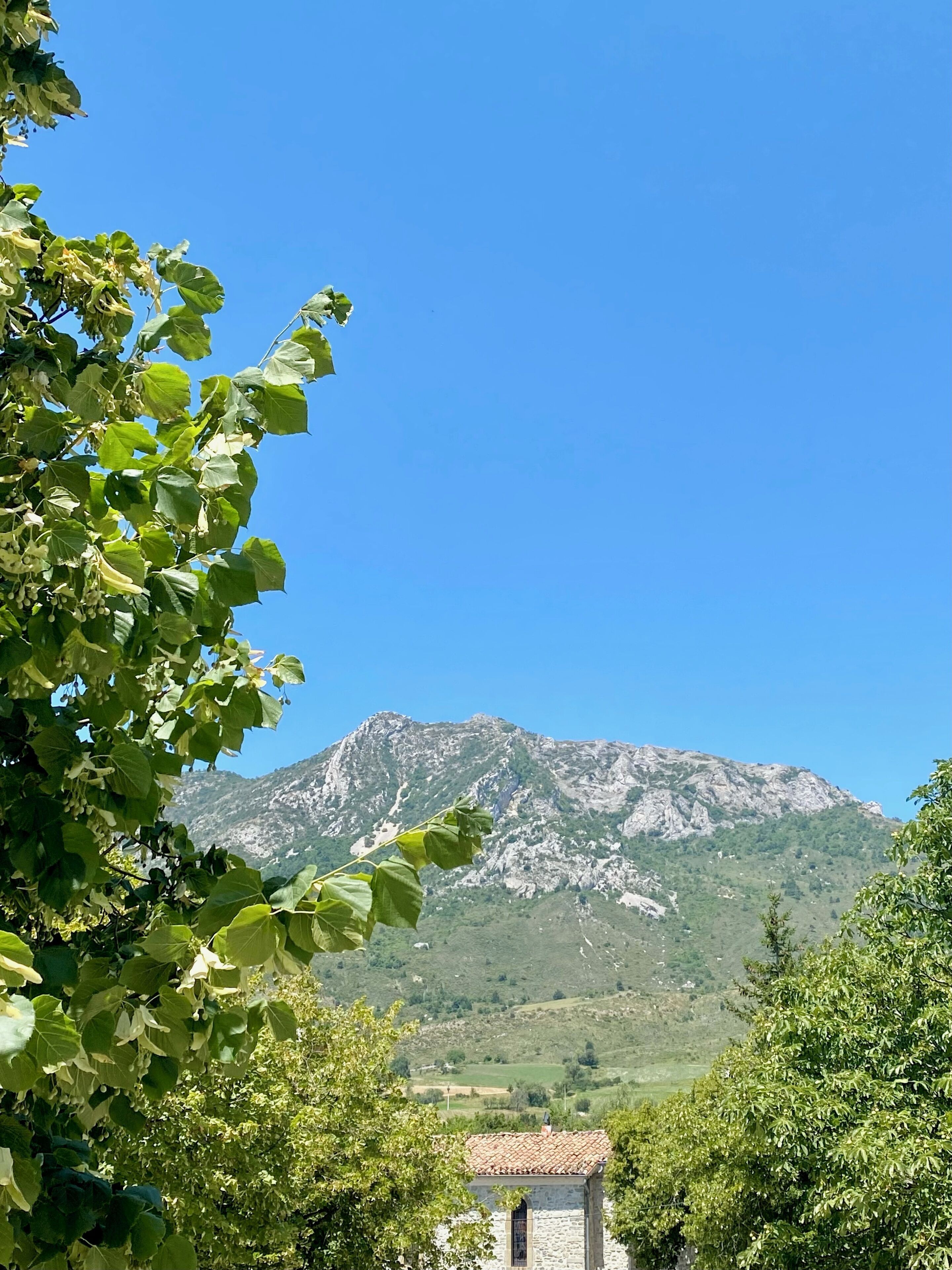 A mountain landscape with a stone building in the foreground.