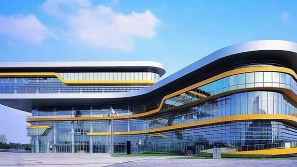 A modern building with curved architecture and large glass windows. - Jizhu Auto Business Hotel (Shanghai)