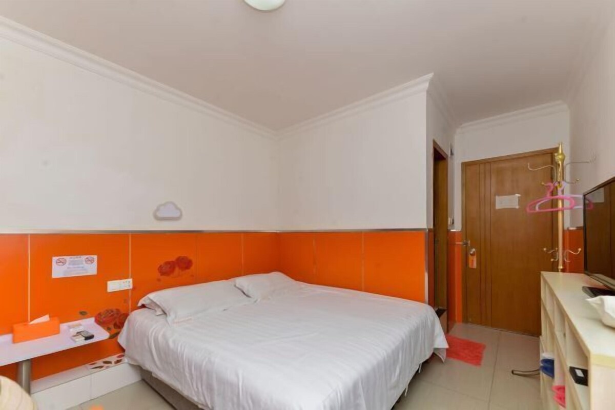 Un dormitorio con cama, escritorio, silla, armario y una puerta.