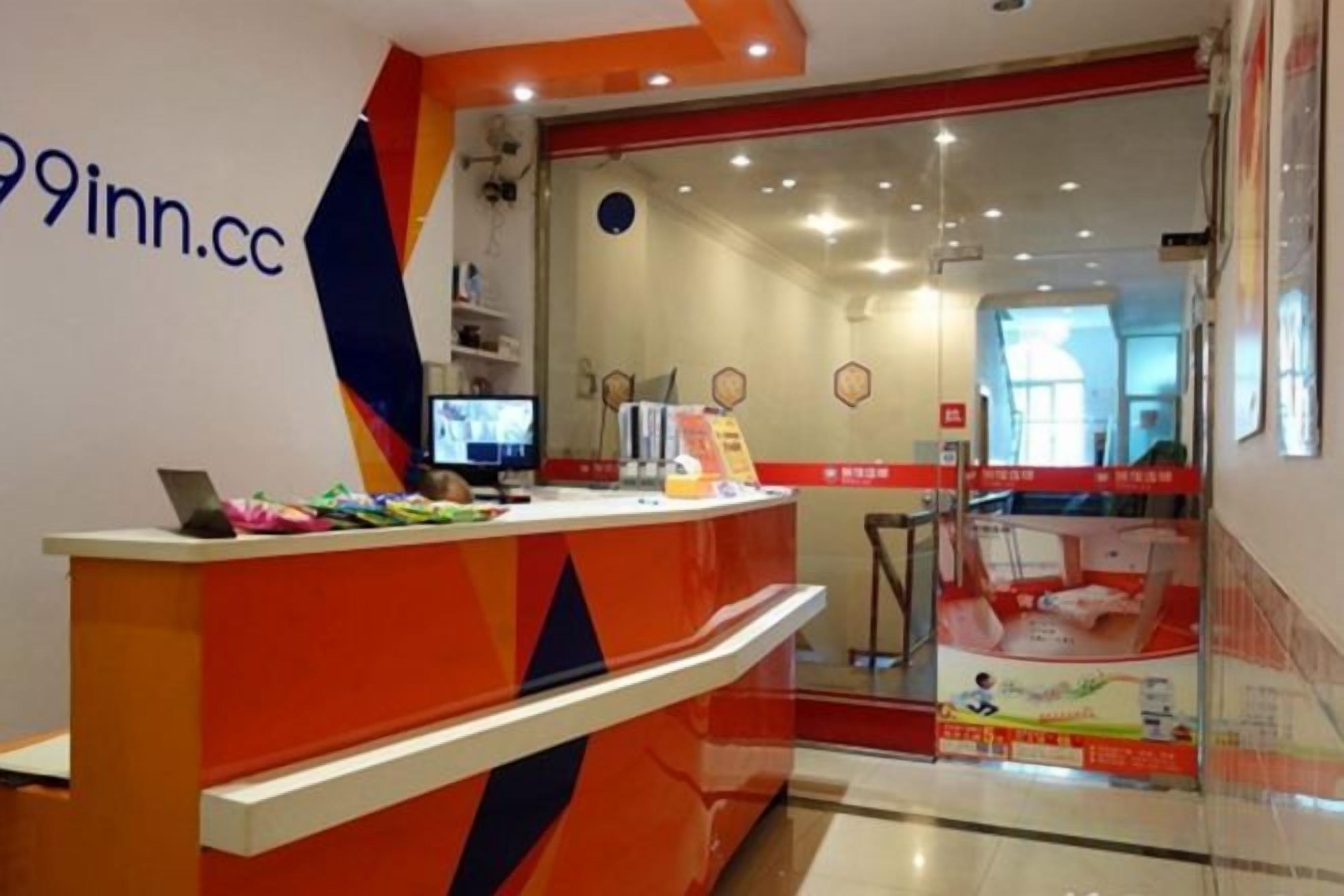 A reception desk with a computer, a phone, and a small table with items on it.