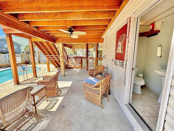 Relax in this serene outdoor space with a pool, wicker chairs, and a table, perfect for unwinding.
