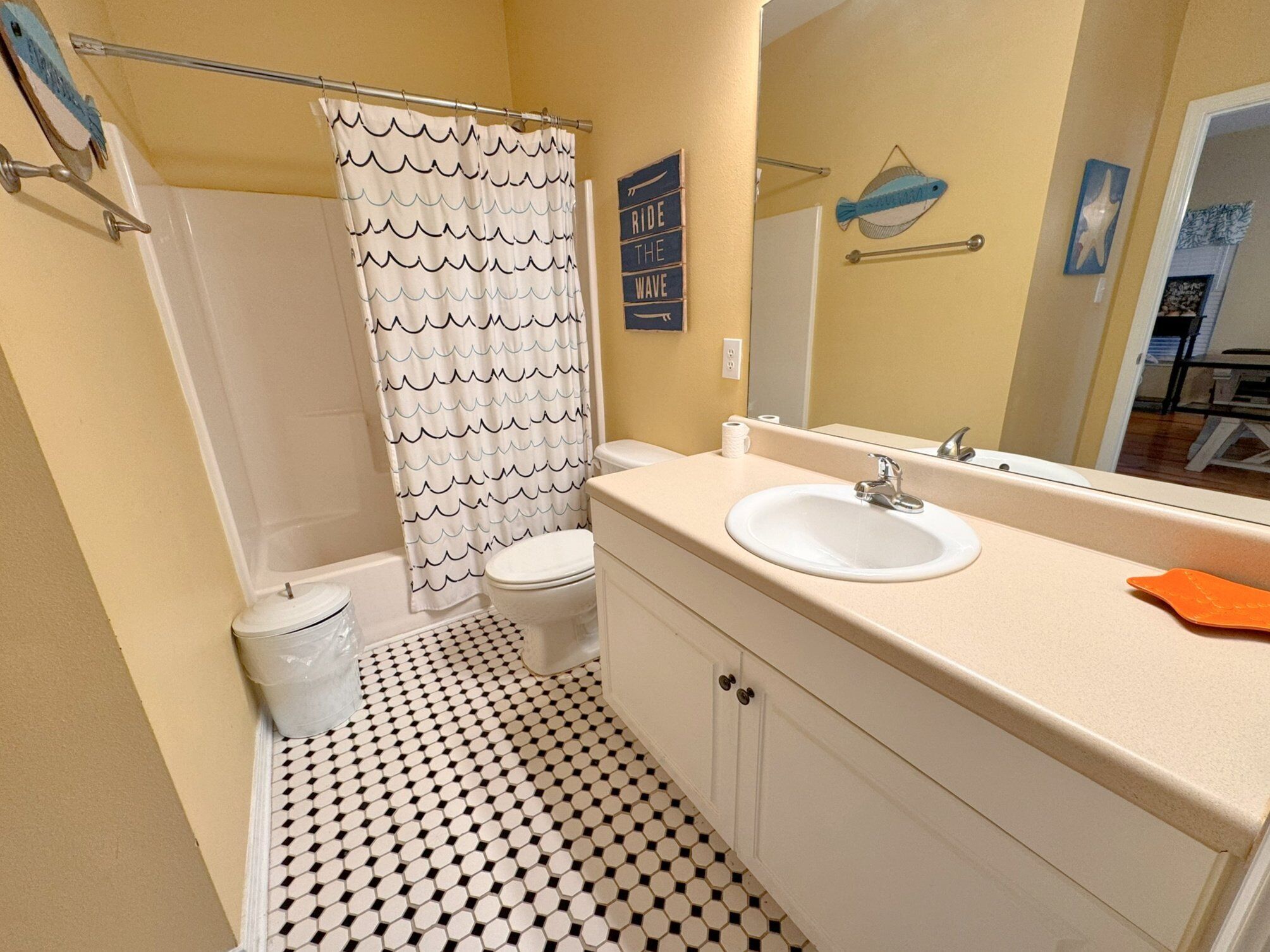 Une salle de bain avec des toilettes, un lavabo et un rideau de douche.