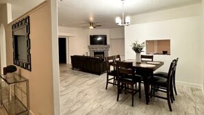 A dining area with a table and chairs, a fireplace, and a television.