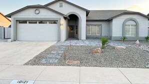 A residential house with a garage, a front entrance, and a landscaped driveway.