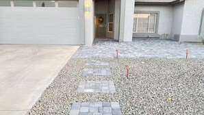 A residential driveway with a gravel path leading to a garage.