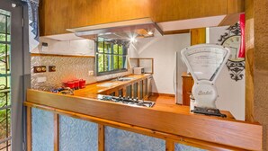 A compact kitchen with a wooden countertop, a gas stove, a sink, and a vintage scale. - StayAU Luxury Candlewick Cottage in Dandenong (Mount Dandenong)