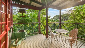 A wooden deck with a table and chairs, surrounded by a railing and lush greenery. - StayAU Owls Croft Picturesque Cottage Valley View (Mount Dandenong)