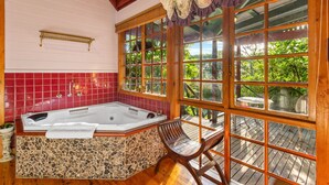 A bathroom with a freestanding bathtub, a wooden bench, and a large window with a view of greenery. - StayAU Owls Croft Picturesque Cottage Valley View (Mount Dandenong)